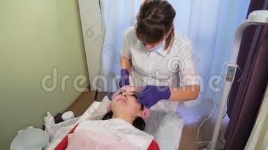 美容师从女人的脸上摘下`面具。 治疗后<strong>皮肤发红</strong>，刺激。 Bb发光